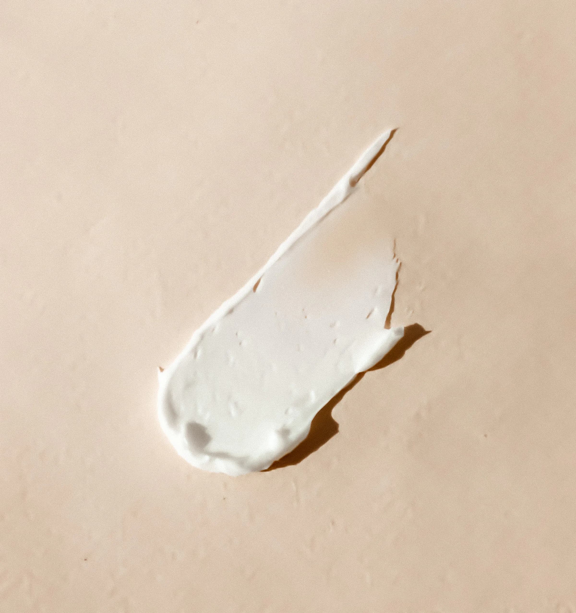 Texture de crème sur fond sable